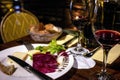 A table is set with wine, cheese, and bread