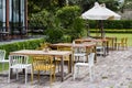 Table sets in outdoor cafes in green garden outside restaurant Royalty Free Stock Photo