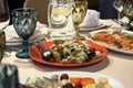 Table setting with appetizers, dishes, salads, glasses and jug of water. Selective focus