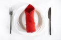Table setting background with red napkin, white plate, fork, knife Royalty Free Stock Photo
