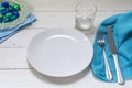 Table setting with blue and turquoise easter eggs, white plate, Royalty Free Stock Photo