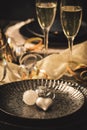 Table setting with decorative heart, two glasses with sparkling wine and party decoration, black and gold colors Royalty Free Stock Photo