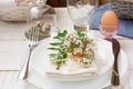 Table setting for Easter, white plates, napkin, bouquet of flowers, green leaves, quail eggs, outdoors, kinfolk Royalty Free Stock Photo