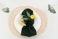 Table setting element lemon slice on a plate, green cloth napkin and yellow flower and two glasses Royalty Free Stock Photo