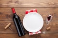 Table setting with empty plate, wine glass and red wine bottle Royalty Free Stock Photo
