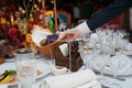 table setting for a festive dinner. waiter places a plate of bread on the table.