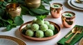 A table setting with green coconut balls, copper cups, and gold utensils on white surface Royalty Free Stock Photo