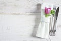 Table setting with handmade forged fork and knife, white linen napkin with ring and purple flower Royalty Free Stock Photo