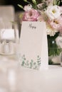 Table setting with menu and fresh flower arrangement. Wedding table decorations. Royalty Free Stock Photo