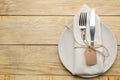 Table setting. Plate and Cutlery in a white napkin fork and knife on a natural wooden table. top view Royalty Free Stock Photo