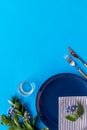 Table setting with plates and flatware on blue background top view mockup