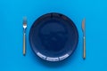 Table setting with plates and flatware on blue background top view