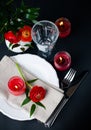 Table setting with red buttercups on a black background Royalty Free Stock Photo