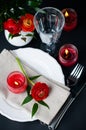 Table setting with red buttercups on a black background Royalty Free Stock Photo