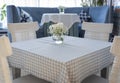 Table setting in restaurant in blue and white colors. Glass vase with white flowers on table in cafe.