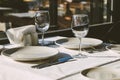 Table setting in restaurant. Empty wine glasses, plates, forks, knifes on the tablecloth. Elegant restaurant interior. Royalty Free Stock Photo