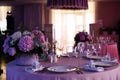 table setting in restaurant in pink color, festive dinner, a bouquet of pink flowers is on the table Royalty Free Stock Photo