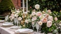 Table setting with rose flowers and candles for an event party or wedding reception in summer garden. Royalty Free Stock Photo