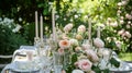 Table setting with rose flowers and candles for an event party or wedding reception in summer garden. Royalty Free Stock Photo