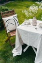 Table setting with tableware, silverware and flowers outdoors Royalty Free Stock Photo