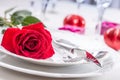 Table setting for valentines or wedding day with red roses. Romantic table setting for two with roses plates cups and cutlery Royalty Free Stock Photo