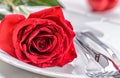 Table setting for valentines or wedding day with red roses. Romantic table setting for two with roses plates cups and cutlery Royalty Free Stock Photo