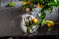 Table setting with white plate, cutlery, linen napkin and orange tree branch decoration on gray linen tablecloth . Close