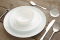 Table setting with white plates, glass, and cutlery - fork, spoon and knife. Shot from above. Copy space on empty plate Royalty Free Stock Photo
