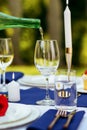 Table setting, wine is poured into a wineglass