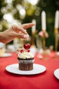 Table setting, woman decorate cake with cherry Royalty Free Stock Photo