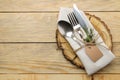 Table setting. wooden stand and cutlery in a white napkin, fork, spoon and knife on a natural wooden table. top view Royalty Free Stock Photo