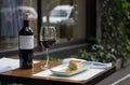 Table setup of a bottle and glass of wine and slice of Spanish omelet with a blurred background