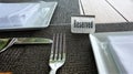 The table sign sits on a placemat made of black woven materia