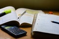 Table with a book, a notebook with math exercises, a calculator and a pen Royalty Free Stock Photo
