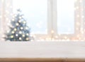 Table with space against blurred Christmas tree and decorated window Royalty Free Stock Photo