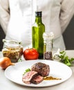 On the table spices, vegetables and a dish of fried medallion Royalty Free Stock Photo