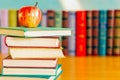 On the table are stacks of books and an apple. Royalty Free Stock Photo