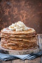 On the table on a stand made of wood cut a pile of thin pancakes