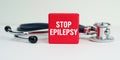 On the table is a stethoscope and a red cube with the inscription - STOP EPILEPSY