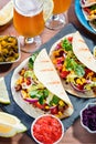 Table with tacos, mango salsa, nachos with sauce, guacamole, lemon beer for Cinco de Mayo celebration party. Appetizers and