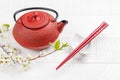 Table with teapot and chopsticks adorned with cherry blossom branch Royalty Free Stock Photo