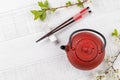 Table with teapot and chopsticks adorned with cherry blossom branch Royalty Free Stock Photo