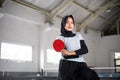 table tennis athlete in hijab holding paddle with crossed hands Royalty Free Stock Photo