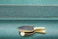 Table tennis or ping pong rackets and ball on green table