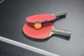 Table tennis racket with orange ball on black Royalty Free Stock Photo