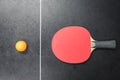 Table tennis racket with orange ball on black Royalty Free Stock Photo