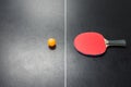 Table tennis racket with orange ball on table Royalty Free Stock Photo