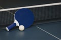 Table tennis rackets and ball and net on a blue pingpong table Royalty Free Stock Photo