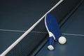 Table tennis rackets and ball and net on a blue pingpong table Royalty Free Stock Photo