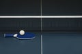 Table tennis rackets and ball and net on a blue pingpong table Royalty Free Stock Photo